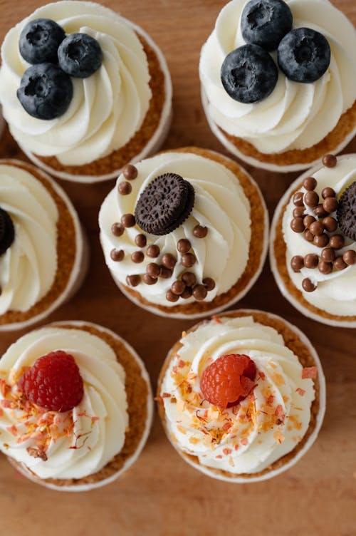 Cupcakes decorated with raspberries and blueberries and sweets with sprinkles