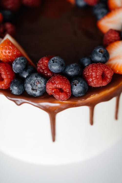 Delicious cake garnished with chocolate frosting and berries