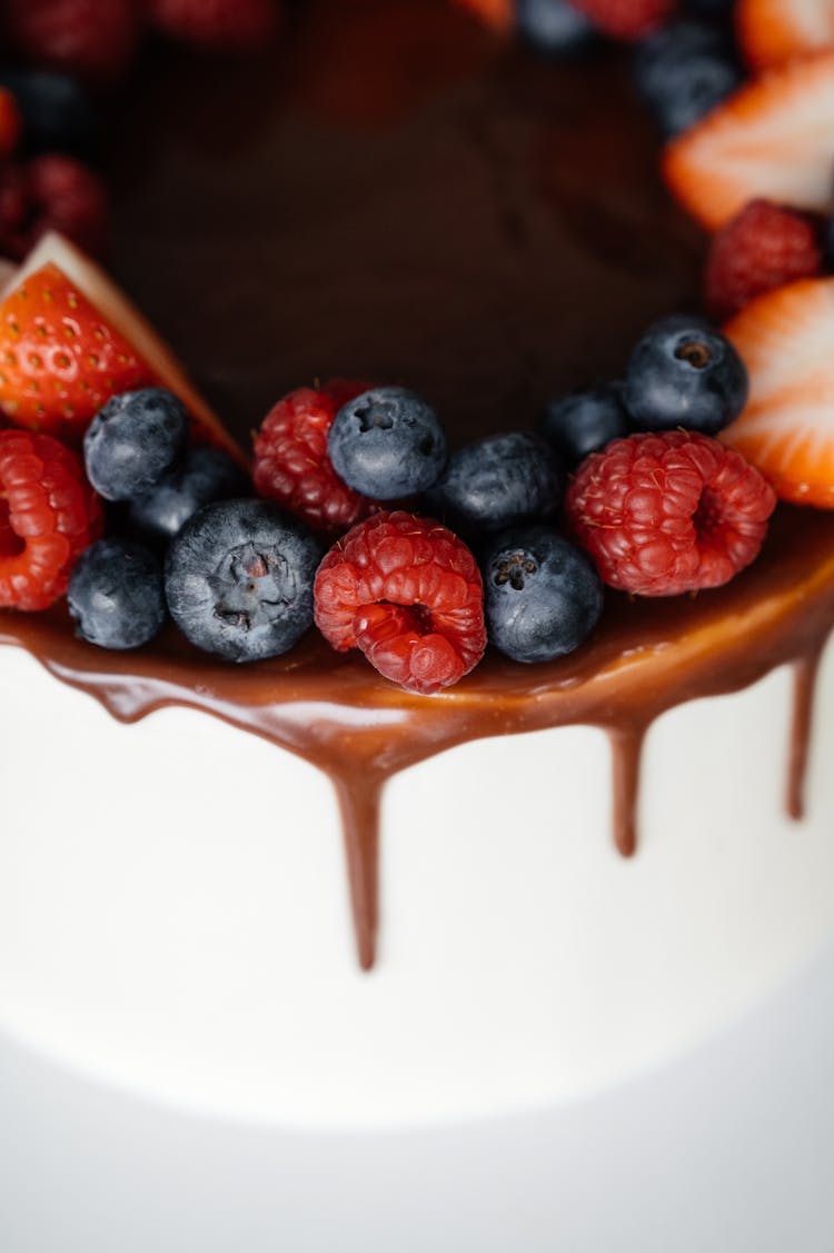 Delicious Cake Garnished With Chocolate Frosting And Berries