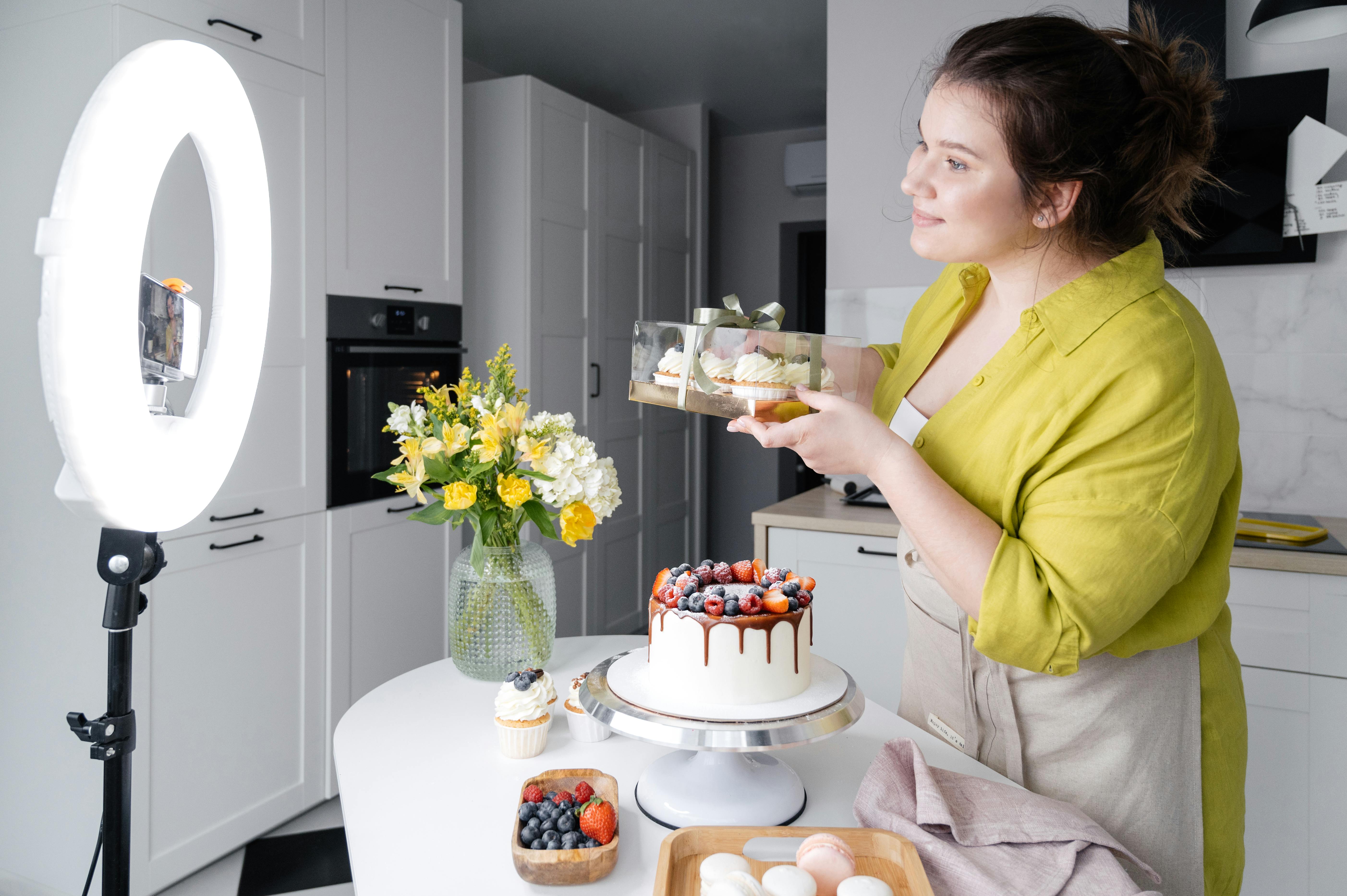 smiling vlogger showing delicious cakes while filming video