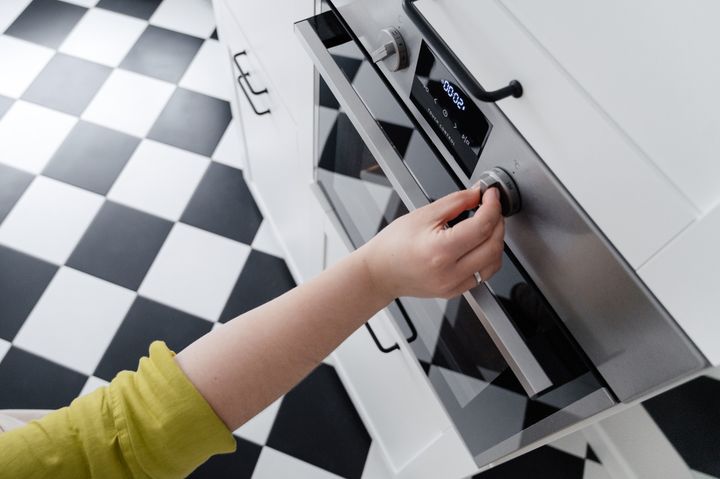Hand adjusting an electric oven control