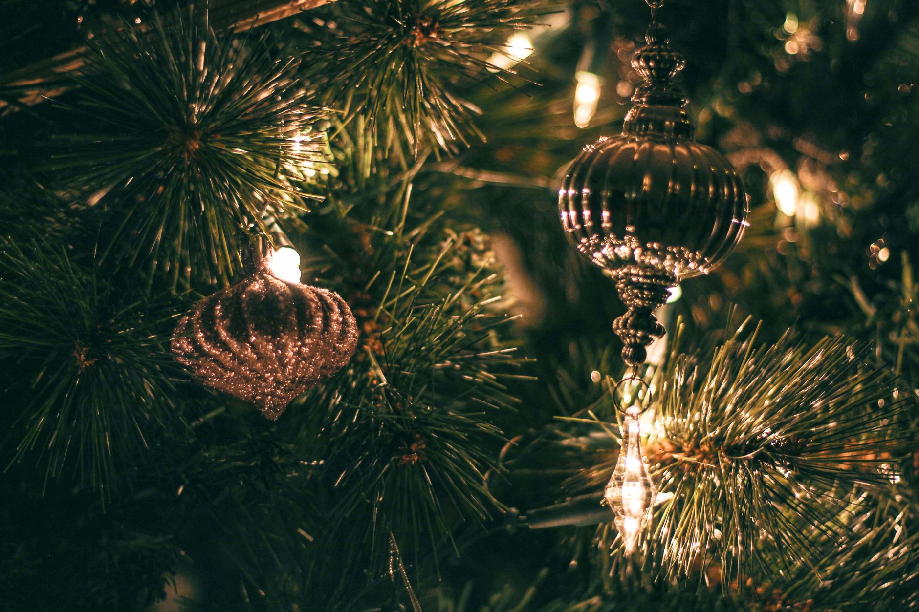 Close-up of sparkling Christmas ornaments hanging on a decorated tree with warm lights. — free online jigsaw puzzle on JigsawPuzzlesFreeOnline.org