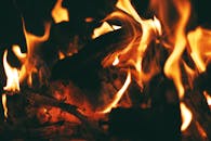 戏剧性的特写镜头捕捉了燃烧的火焰和余烬消耗木柴时散发的强烈热量