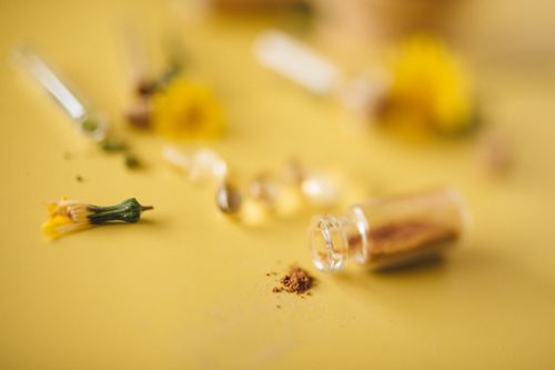 Free Close-up of herbal powder and flowers on a yellow surface, concept of natural remedies. Stock Photo