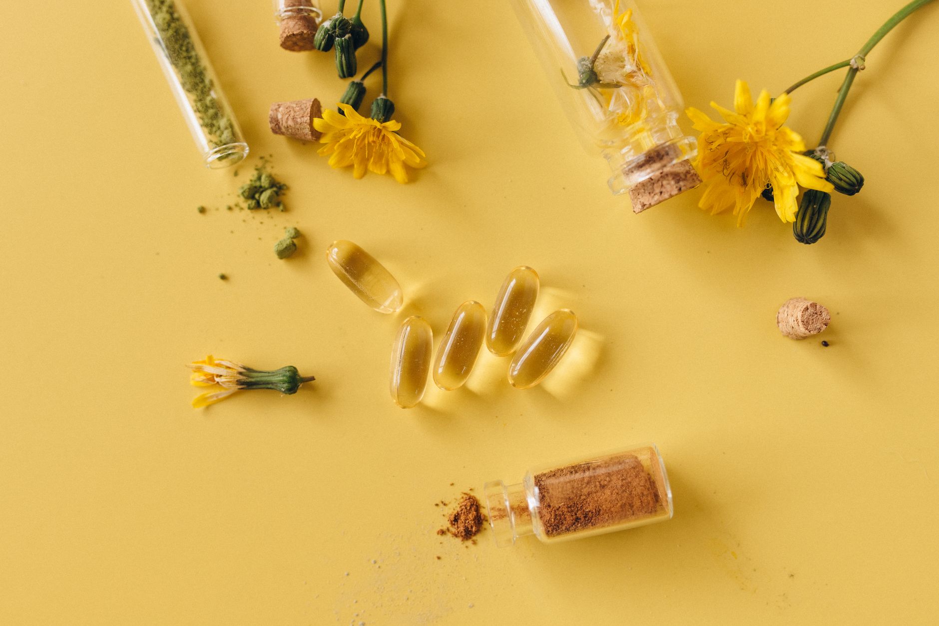 close-up of natural sleep supplement ingredients including dried berries, chamomile flowers, and herbal capsules arranged on a marble surface