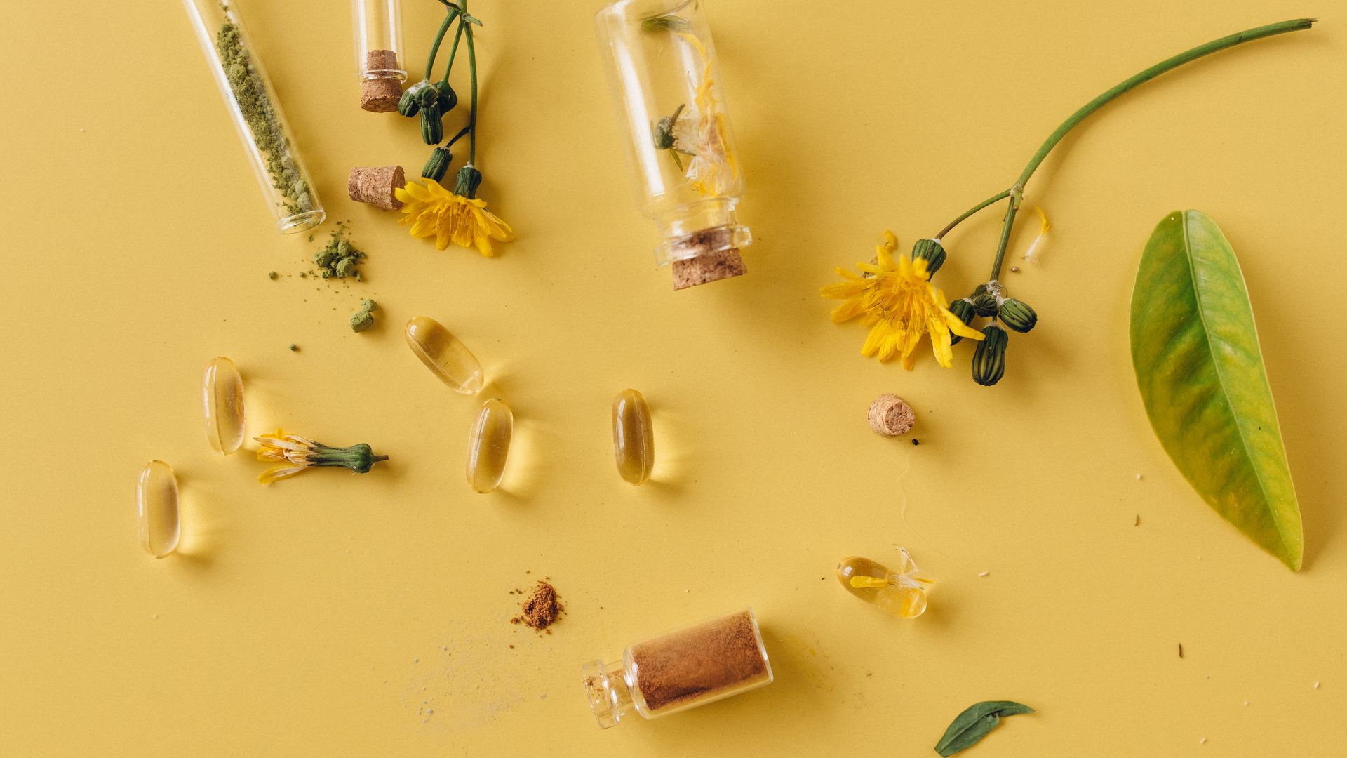Modafinil vs Green Tea Extract: A Comprehensive Comparison A flat lay of glass bottles, capsules, and flowers on a vibrant yellow surface, representing natural remedies — modafinil vs green tea extract