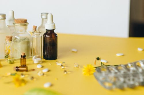Free Assorted bottles and capsules on a yellow surface, highlighting natural remedies. Stock Photo