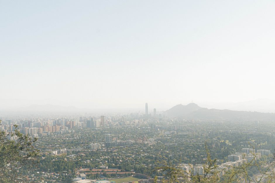 A wide-angle view of Santiago's skyline under a bright sky, capturing urban and mountainous landscapes.