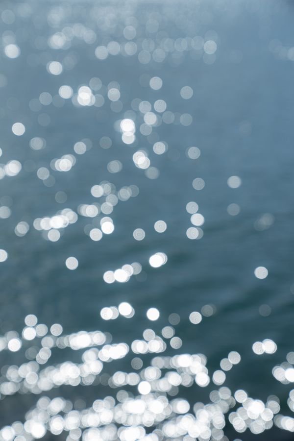 Sunlight scattering across rippled blue water — photo by belen capello on Pexels