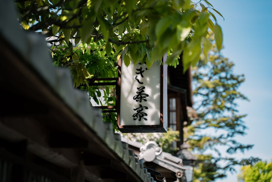 京都、日本の伝統的な看板で、緑の豊かな環境に囲まれています。