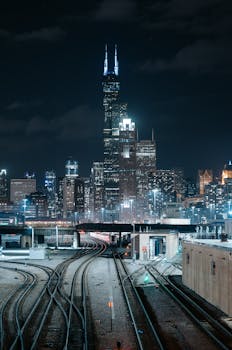 A stunning view of Chicago's skyline and train tracks at night, showcasing urban architecture.
