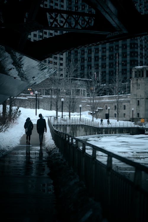 Free People Walking on a Bridge Near a Frozen River Stock Photo