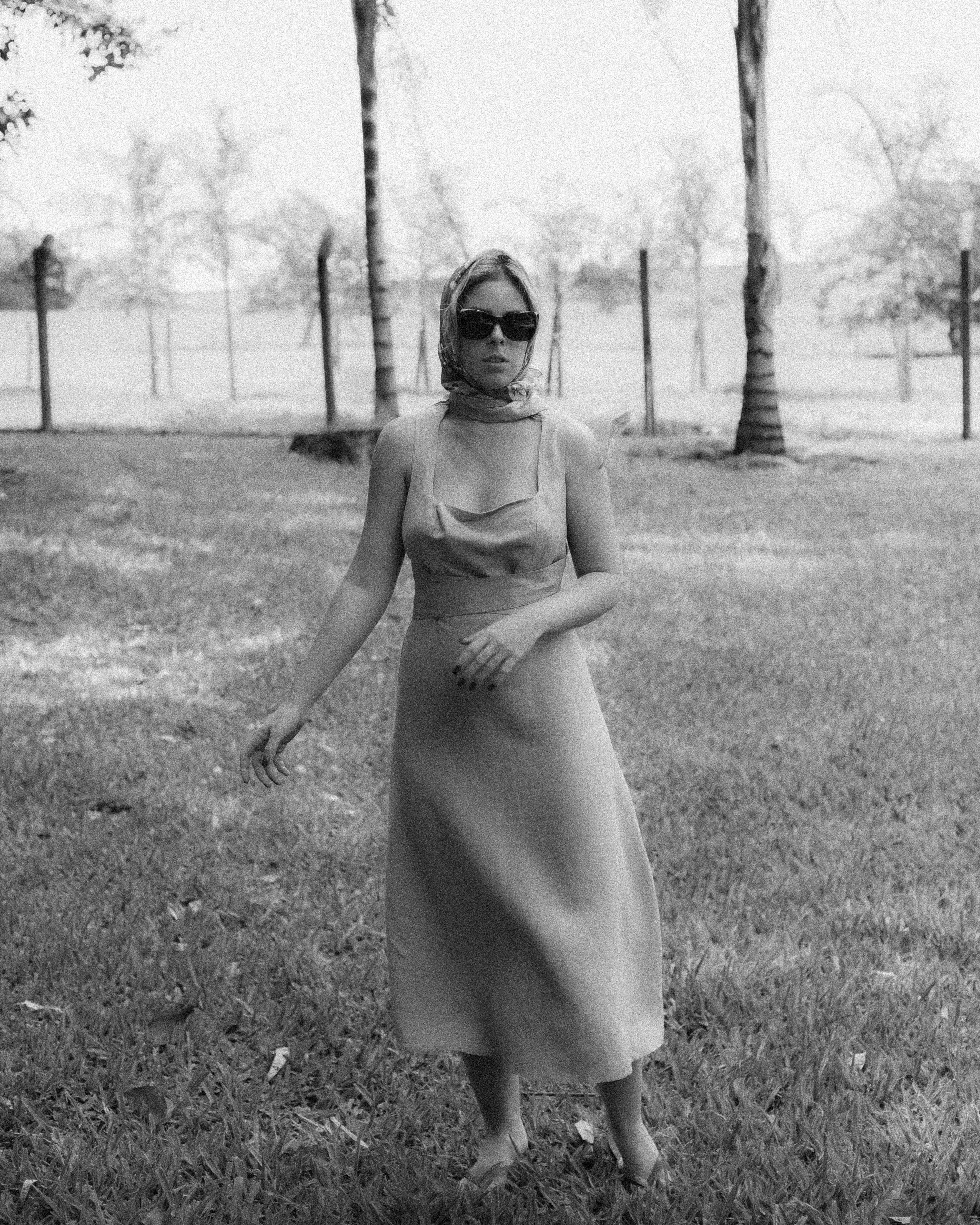 Woman in White Dress Standing on Grass Field