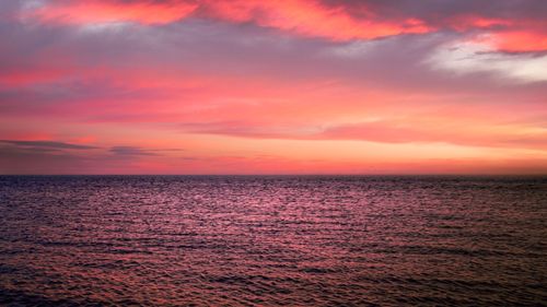 Free A breathtaking view of the ocean at sunset with a vibrant, colorful sky. Stock Photo