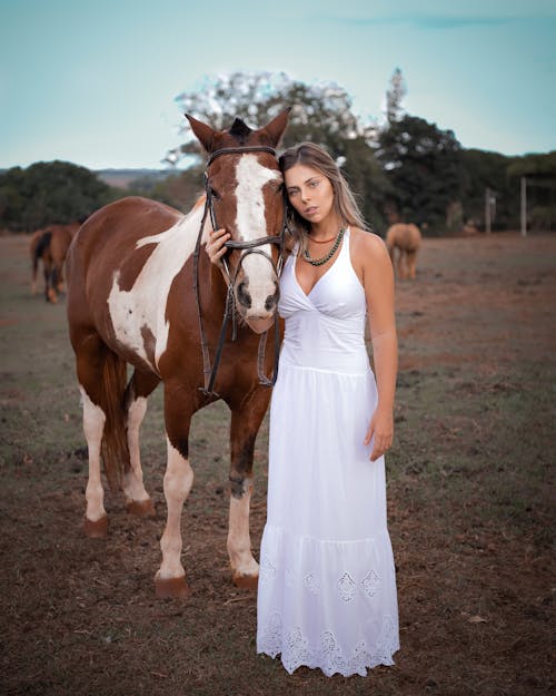 Woman Standing Beside a Brown Horse