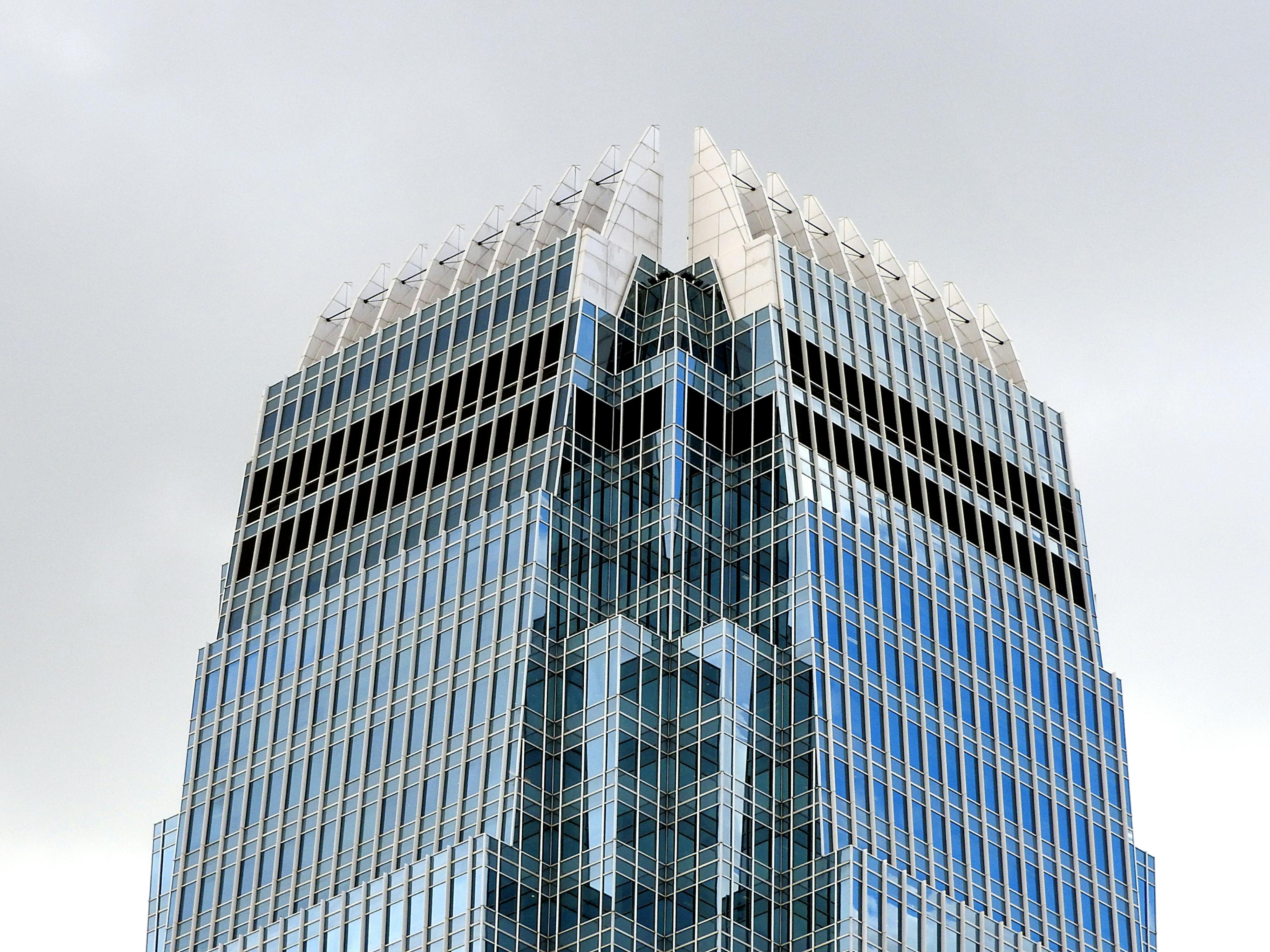 Creative exterior of futuristic multistory building with multicolored glass balconies against gloomy sky
