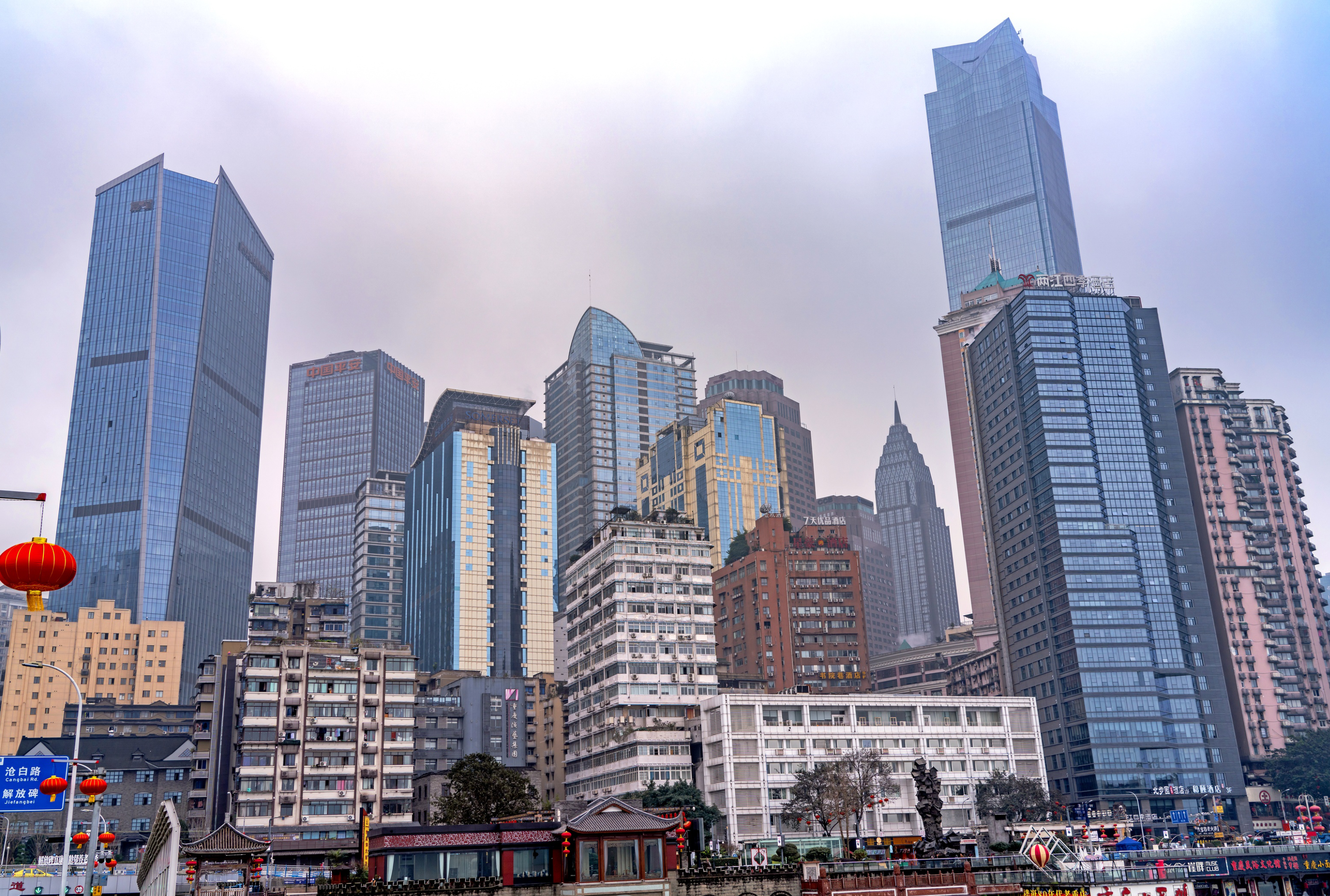 Vibrant skyscrapers in Chongqing's urban skyline under a gloomy sky.