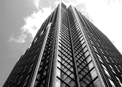From below black and white of contemporary multistory house exterior against cloudy sky