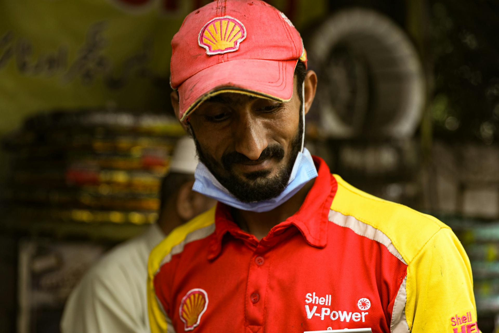 Shell V-Power employee wearing a red and yellow uniform in Lahore, Pakistan.