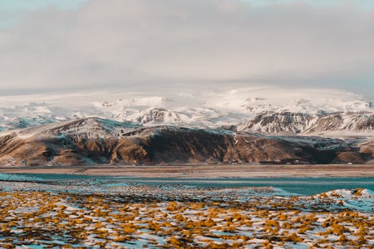 Breathtaking view of Iceland's snow-capped mountains and serene lake in a winter landscape.