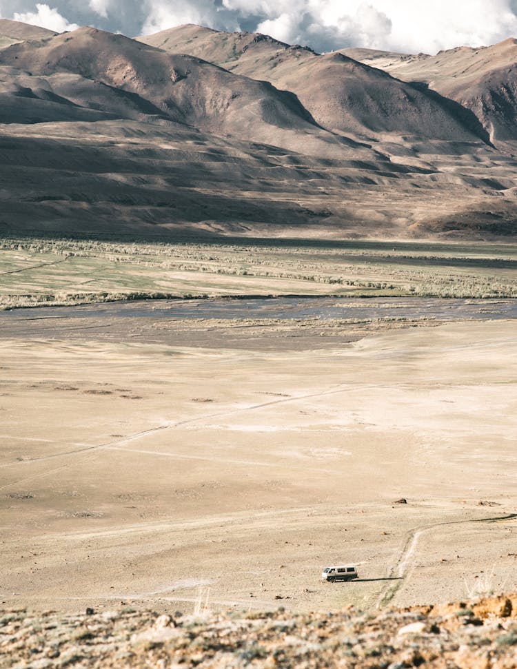 Vehicle On Rough Terrain Against High Mountains