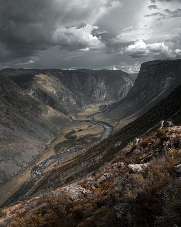 Canyon with curved river under cloudy sky in twilight