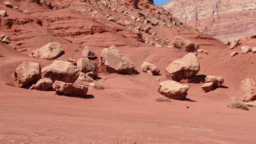 Free A scenic view of an arid desert landscape with striking red rock formations under a clear sky. Stock Photo