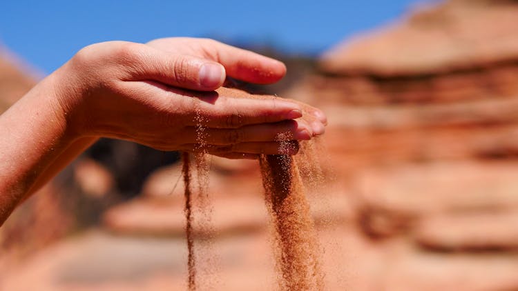 Sand Falling From A Person's Hands