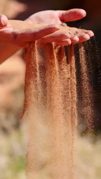 A serene moment captured as sand flows gently through human hands, symbolizing time and zen.
