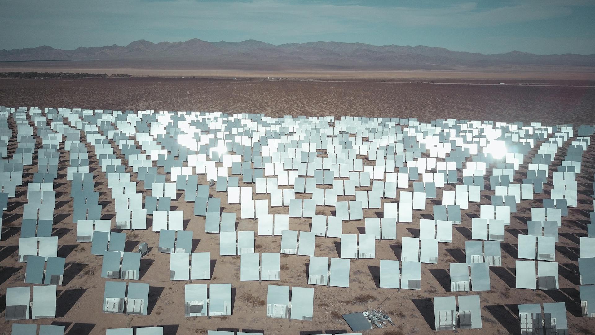 Expansive solar panel field in a sunny desert, capturing renewable energy.