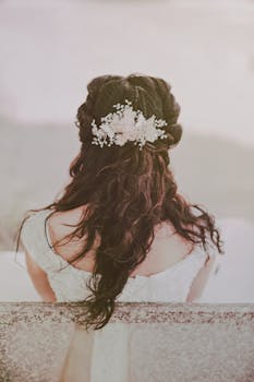 新娘的发型优雅，点缀着花卉装饰，背影非常适合户外婚礼
