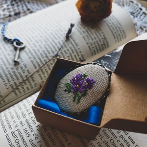 Hand-stitched floral brooch in a paper box — photo by Olga Kalinina on Pexels