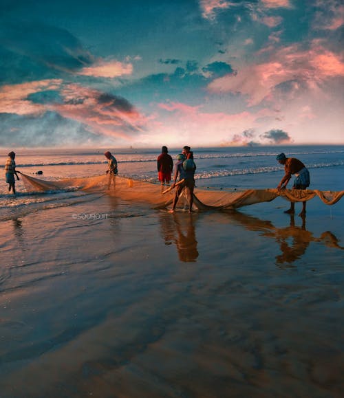 People on Seashore Holding a Fishing Net