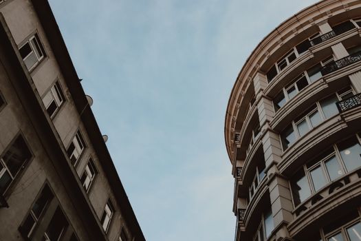 Low angle view of modern city architecture against blue sky, highlighting geometric design.