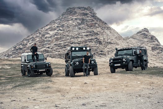 Off-road vehicles and men exploring a rocky hill in Razavi Khorasan, Iran.