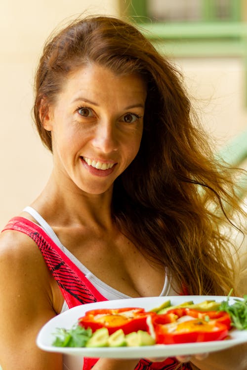 A Woman Smiling while Holding a Plate with Food