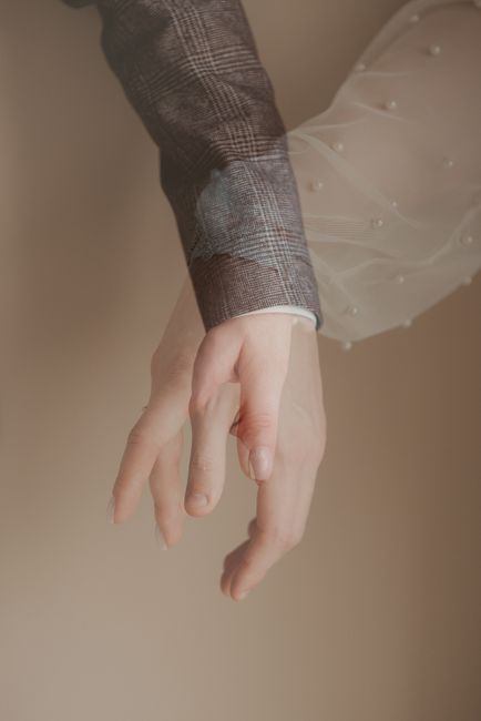 Artistic multi-exposure photo of a couple's hands in wedding attire, symbolizing love and connection.