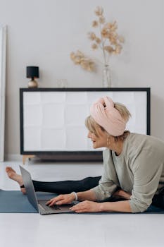Elderly woman engaging in online yoga session at home, promoting a healthy lifestyle.