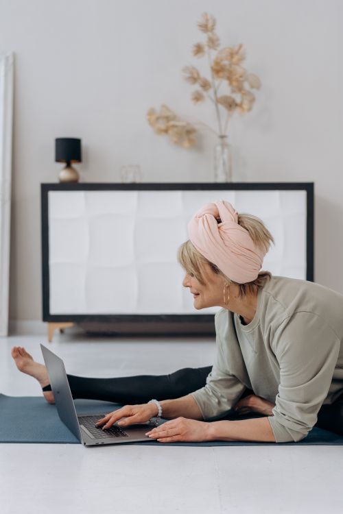 Free Elderly woman engaging in online yoga session at home, promoting a healthy lifestyle. Stock Photo
