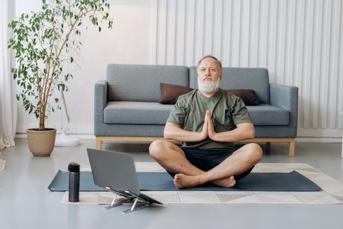 Free Elderly man meditating on yoga mat indoors, promoting healthy lifestyle. Stock Photo