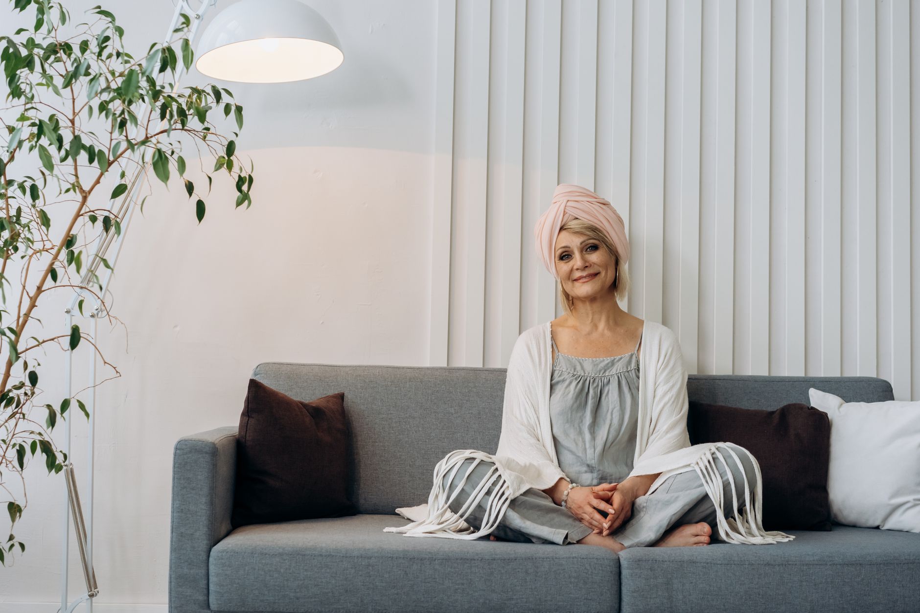A senior laughing on her sofa at home