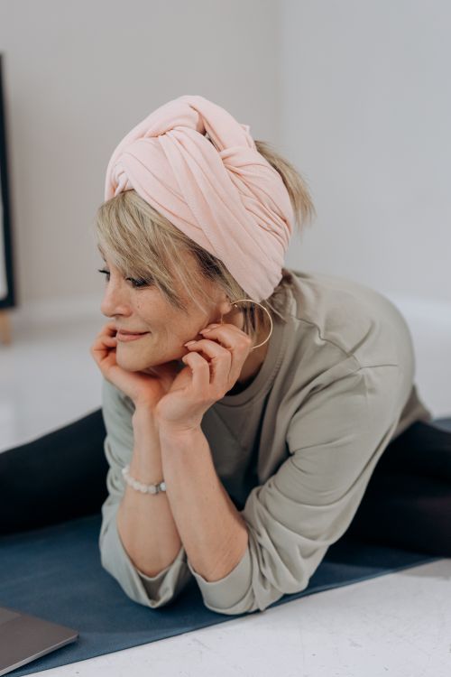 Free Senior woman in comfortable clothing relaxing on a yoga mat in her living room, embodying a healthy lifestyle. Stock Photo