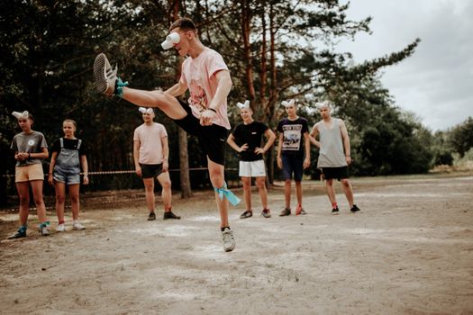 A group of people enjoying an outdoor game with fun eye covers and energetic movements.