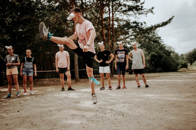 A Man Wearing Improvised Eye Cover Made Of Disposable Cups While Jump Kicking