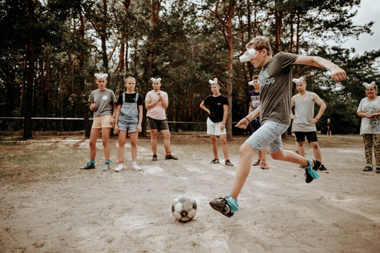 A Group Of People Wearing Improvised Eye Cover Made Of Disposable Cups While Playing Soccer