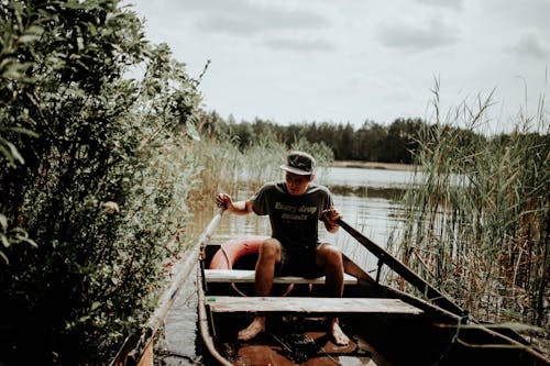 A Man Paddling a Boat on Lake