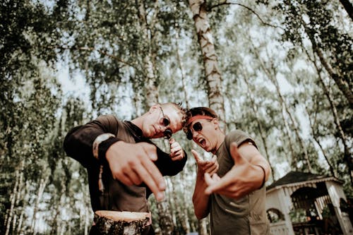 Men Wearing Sunglasses Standing Under the Trees