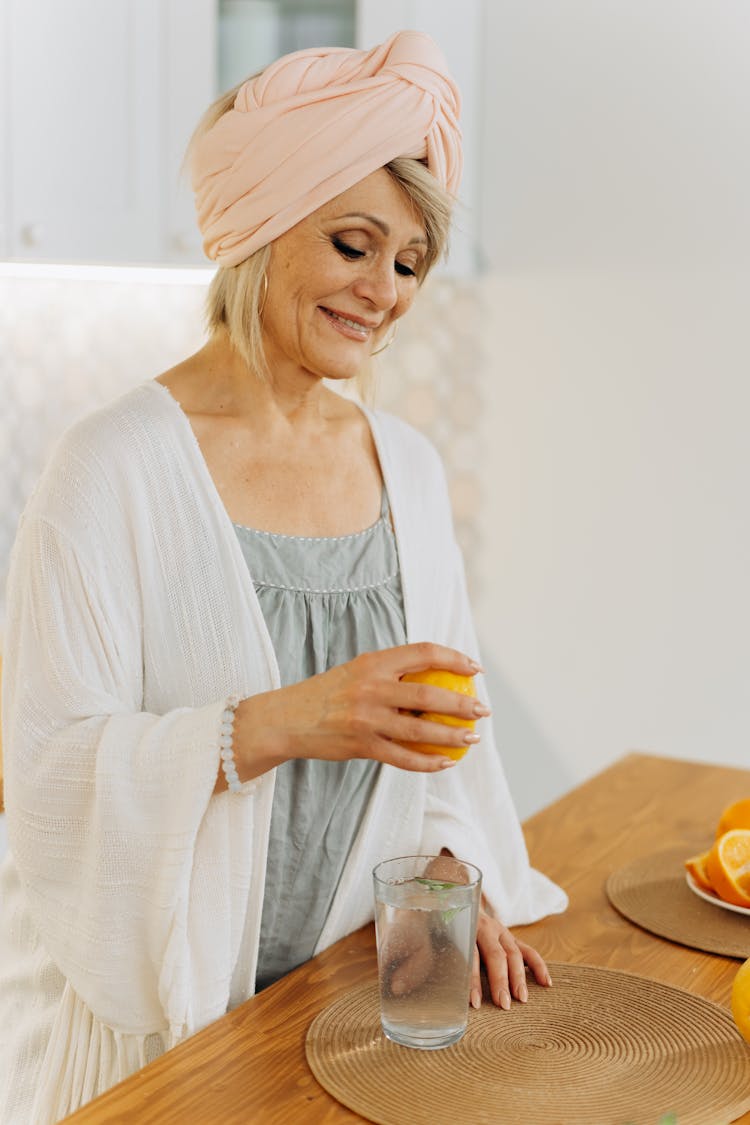 Woman Smiling While Squeezing Lemon