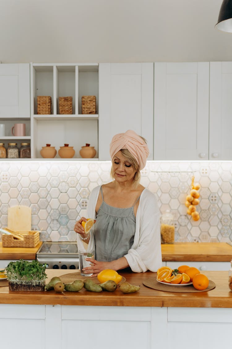 Woman Squeezing Lemon In A Kitchen