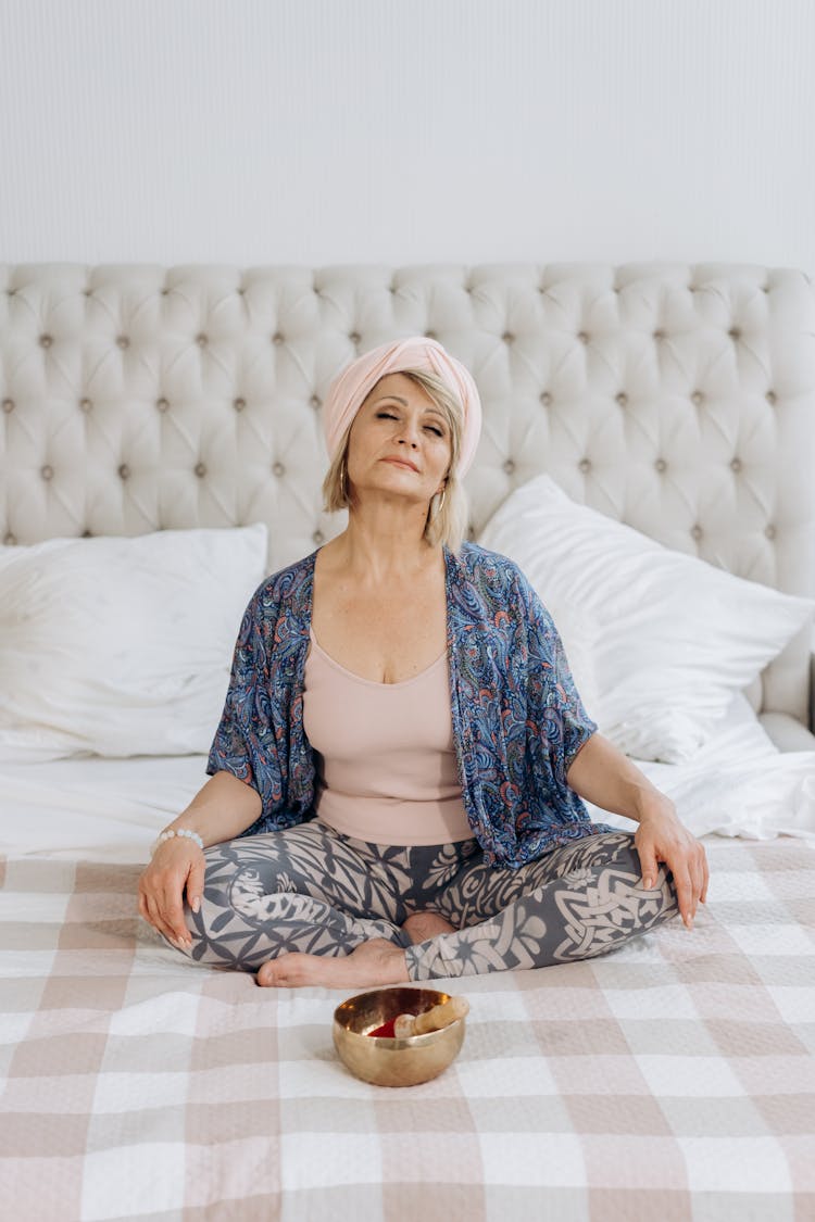 Woman Sitting On Bed With A Golden Bowl